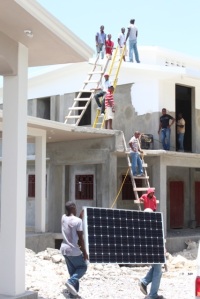 Solar panel being brought from the clinic to the ladders and waiting “brigade”