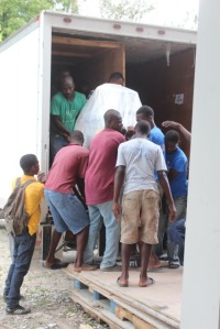 Taking equipment off the truck with the help of local Haitian men